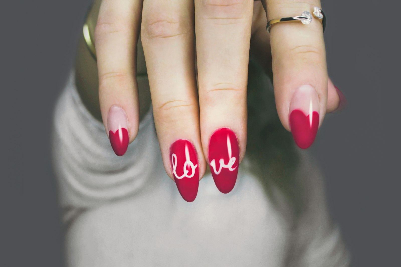 Amandelvormige nagels in diep rood met een fijne handgeschilderde tekst