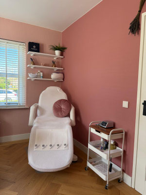 De behandelruimte van 4 Ur Nails met pedicurestoel tegen een warme dusty-rose muur
